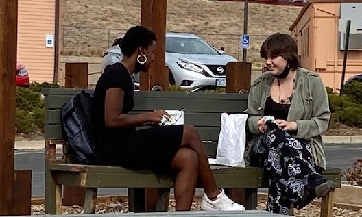 Two AVC student eat lunch outside.
